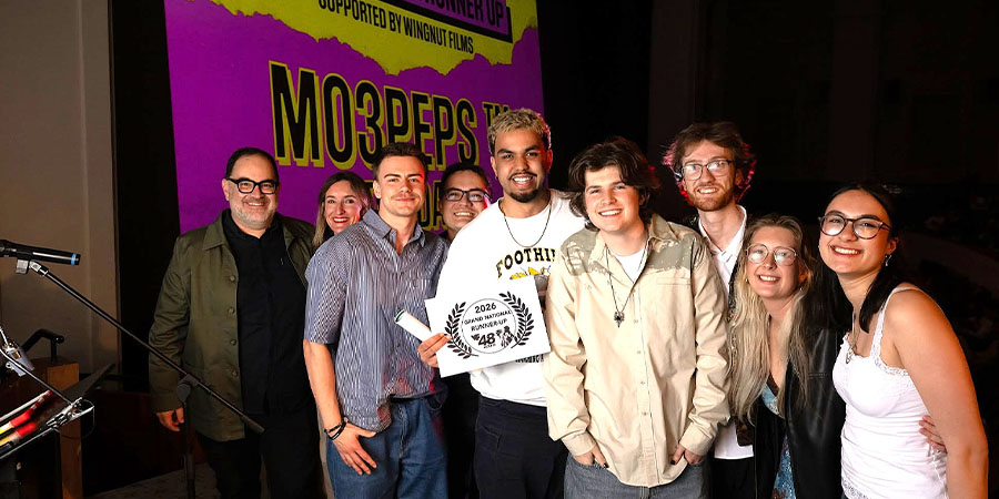 A group of people in casual clothes smile for the camera.