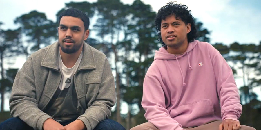 Two people sit outside looking into the distance.