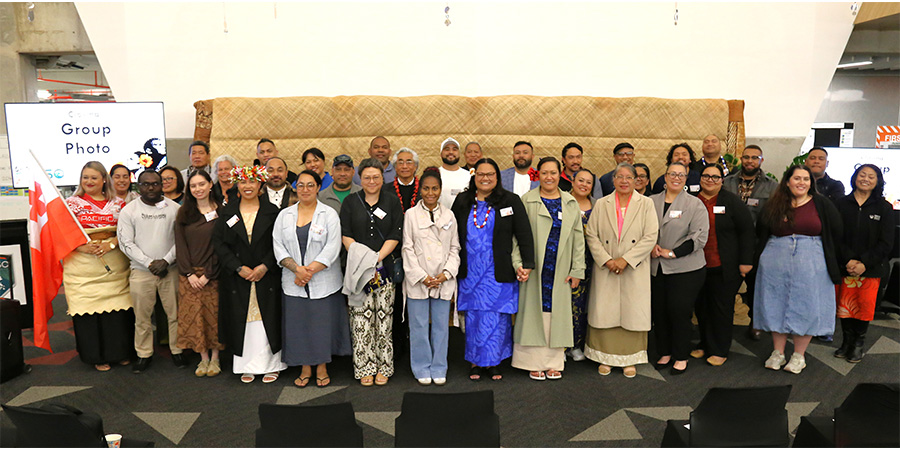 A large group of adults in business attire pose for a photo.