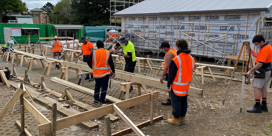 Carpentry students in high-vis vests at work on site at Mt Albert campus.