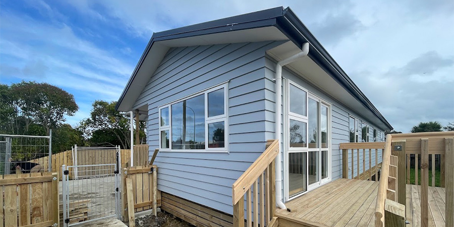 One of the student-built houses installed on its site in the sunshine.
