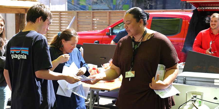 A woman hands a young man a certificate.