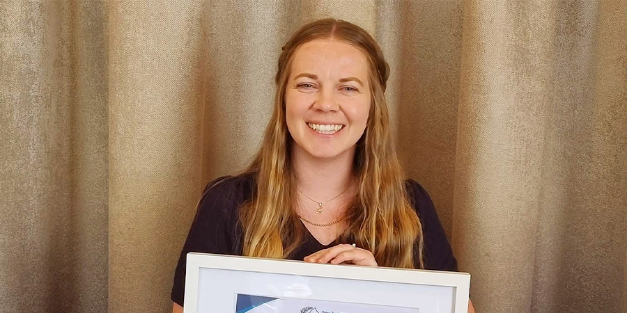 Lauren Prior smiles with her award certificate.